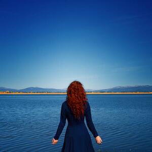 Photography Redhead in blue dress faces rippled lake, Anna Gorin, (40 x 40 cm)