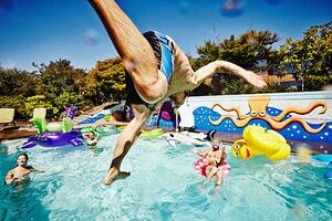Art Photography Man in mid air jumping into pool during party, Thomas Barwick, (40 x 26.7 cm)