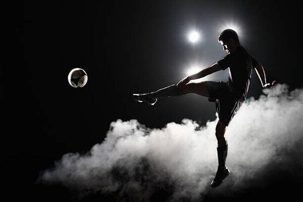 Photography Soccer player kicking the ball at night on stadium, Stanislaw Pytel