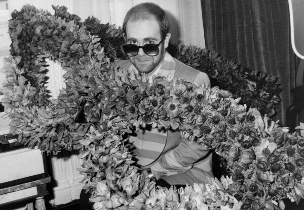 Photography English Singer Elton John at his Arrival in Paris : Bunch of Flowers in The Shape of Glasses He Wears, December 1St, 1976